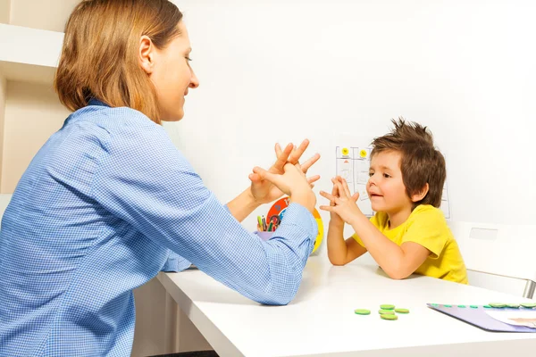 Boy exercises putting fingers with therapist — Stock Photo, Image