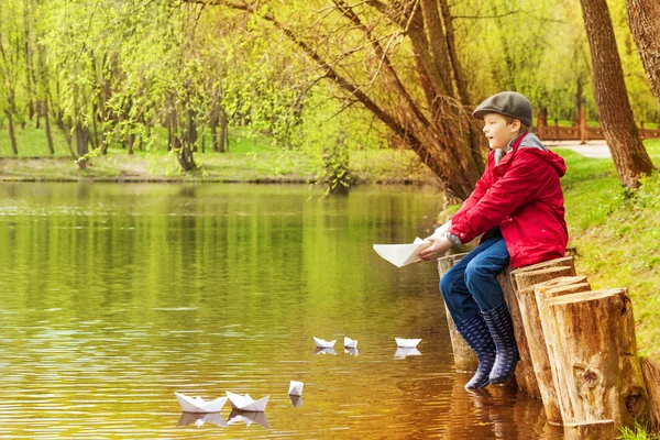 Junge spielt mit Papierbooten — Stockfoto