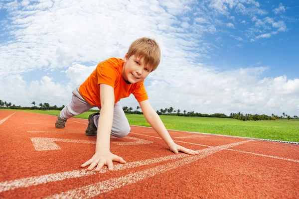 Sorrindo menino no início pronto para correr — Fotografia de Stock