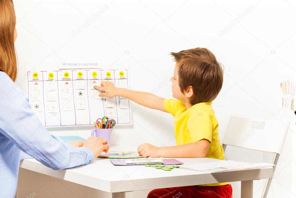 Boy points at activities on calendar