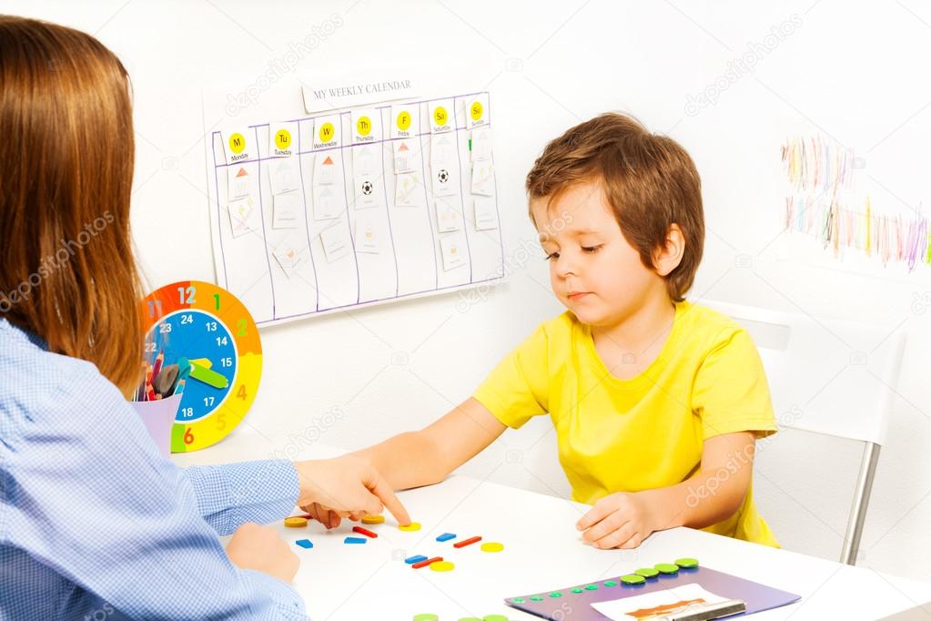 Boy putting colorful shaped coins