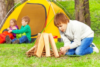 Çocuk ormandaki şenlik ateşi hazırlar
