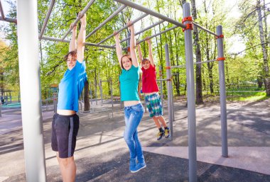 Gençler brachiating çubuğunda asılı