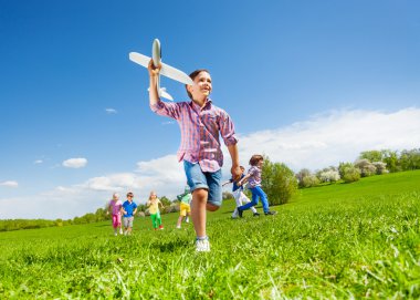 boy with toy and kids running