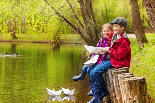 Rindo menina e menino com barcos de papel — Fotografia de Stock