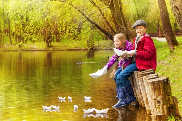 Flicka och pojke spela med papper båtar — Stockfoto