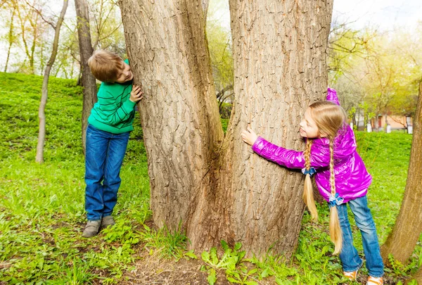 Boy and girl playing hide-and-seek — Stock Photo, Image