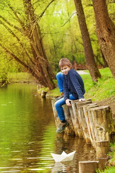 Junge sitzt in Teichnähe — Stockfoto