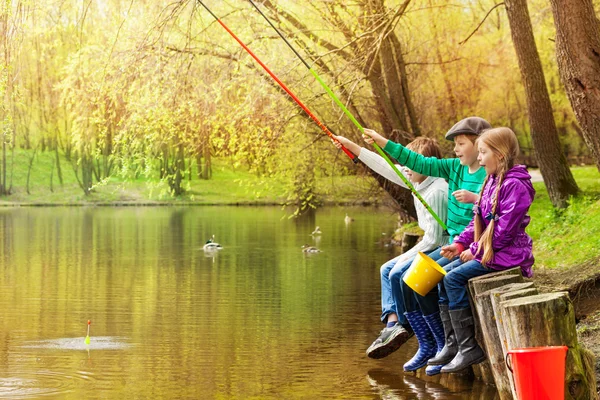 Happy friends sit fishing together