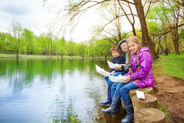 Smiling friends hold paper boats — Stock Photo, Image