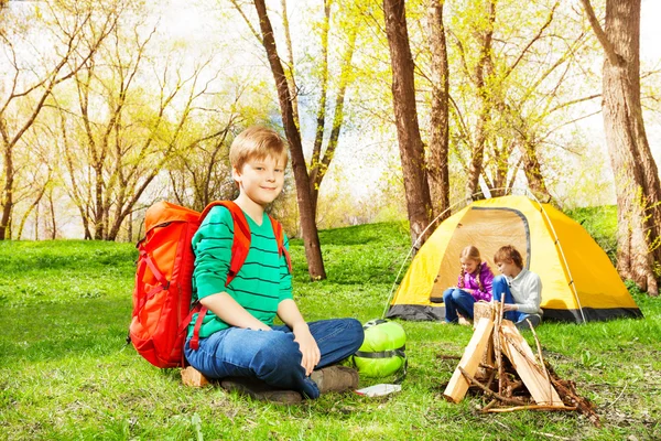 Lycklig pojke med ryggsäck vilande på camp — Stockfoto