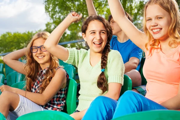 Glückliche Teenager jubeln ihrem Team auf der Tribüne zu — Stockfoto