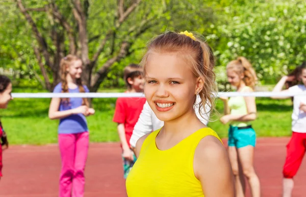 Blond dziewczynka i przyjaciółmi gry w siatkówkę — Zdjęcie stockowe