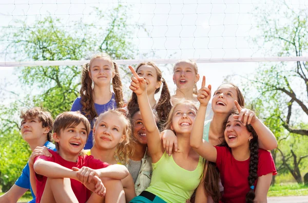 Les adolescents assis sous le filet de volley-ball — Photo