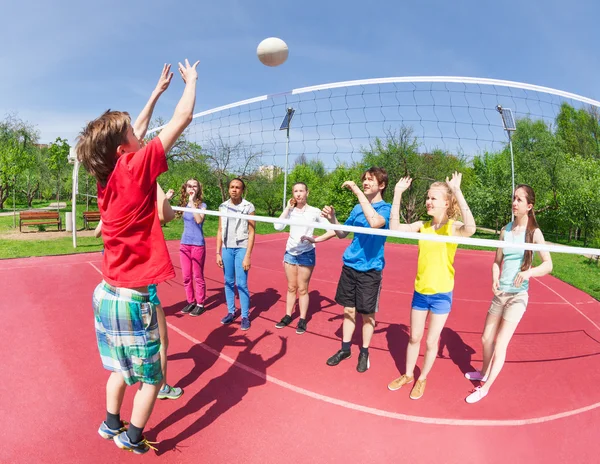 Garçon et filles actifs jouant au volleyball — Photo