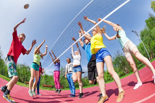 Подростки играют в волейбол на земле — стоковое фото