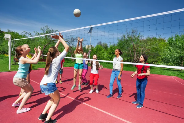 Tienermeisjes en boy spelen volleybal — Stockfoto