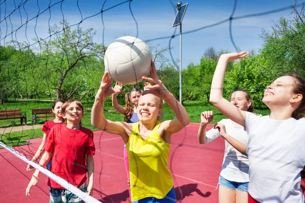 Adolescentes juegan cerca de la red de voleibol — Foto de Stock