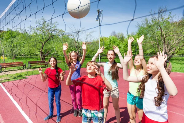 Group of teens playing volleyball near net — Stock Photo, Image