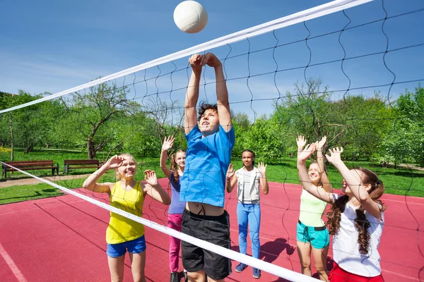 Jugendliche mit erhobenen Armen spielen Volleyball — Stockfoto