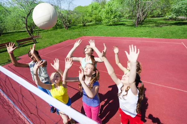 Teenager mit erhobenen Armen spielen Volleyball — Stockfoto