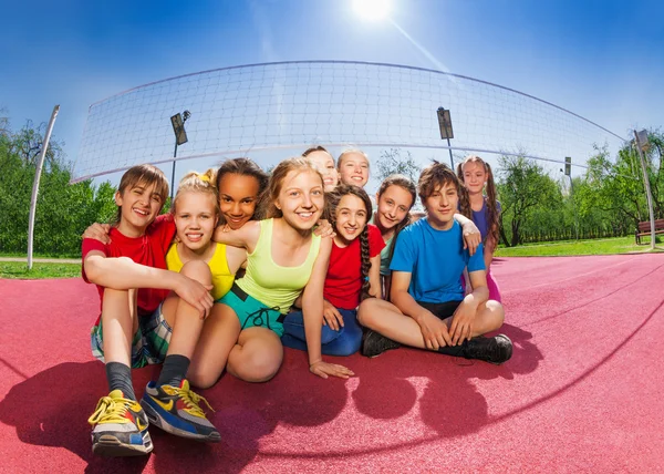 Amigos felices en la cancha de voleibol juego — Foto de Stock