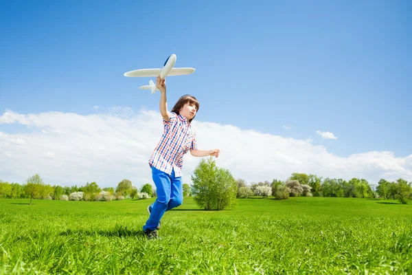 Мальчик играет с игрушкой для самолета — стоковое фото