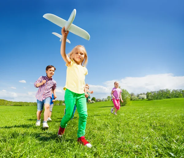 Crianças correndo felizes com brinquedo de avião — Fotografia de Stock