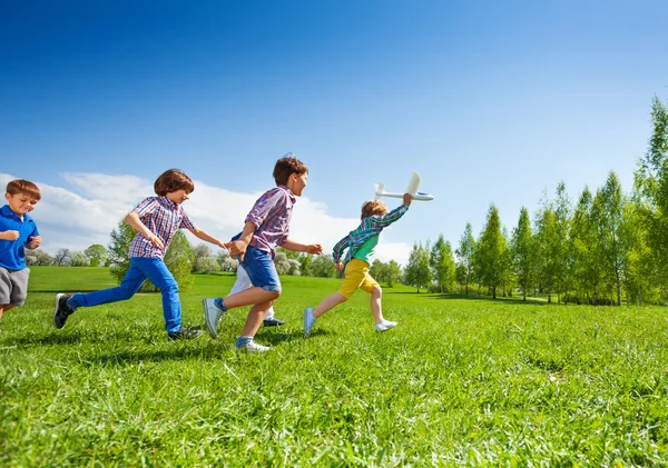 Crianças correndo felizes com brinquedo de avião — Fotografia de Stock