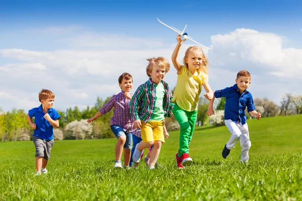 Happy running kids with airplane toy — Zdjęcie stockowe