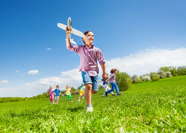 Junge mit Spielzeug und Kinder rennen — Stockfoto