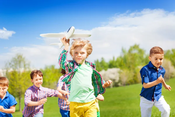 Happy running children with airplane toy — Stockfoto