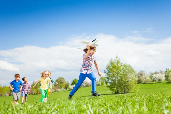 Junge mit Kindern läuft mit Flugzeugspielzeug — Stockfoto