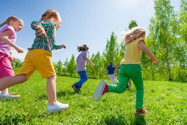 Children running in green park — Stok fotoğraf