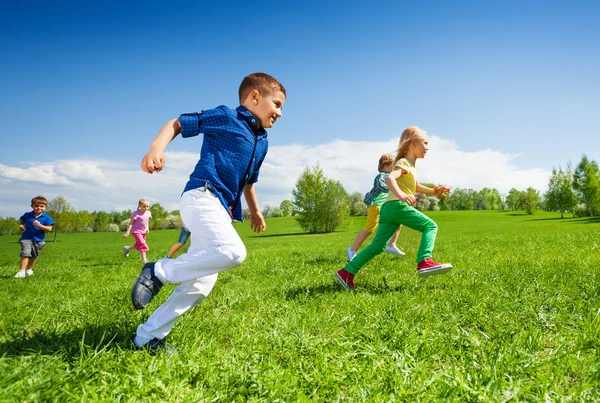 Happy running kids in green park — Stock fotografie