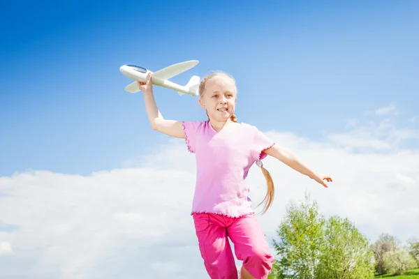 Happy girl holding airplane toy — Stok fotoğraf