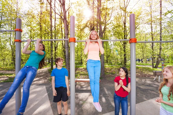 Happy children chinning up on playground — Stock Image Happy children chinning up on playground Stock Photo