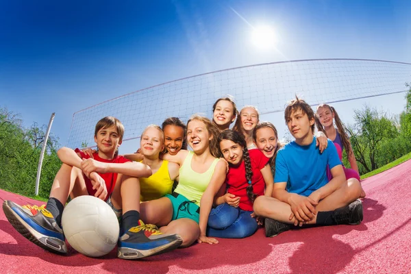 Adolescentes felizes no campo de jogo de vôlei Imagem De Stock