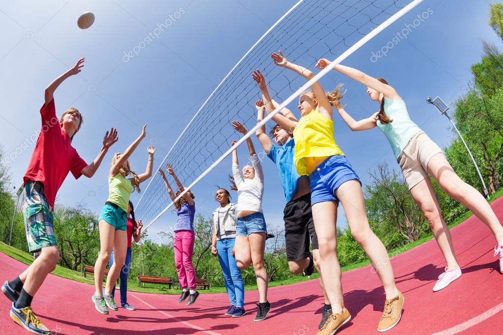 Teens playing volleyball on ground Stock Photo by ©serrnovik 77385760