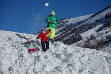 Üç kardeş, Noel tatilinin tadını çıkardıktan sonra dağ yamacında kavga ederek eğleniyor.