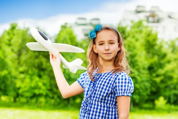 Mädchen hält Flugzeugspielzeug in der Hand — Stockfoto