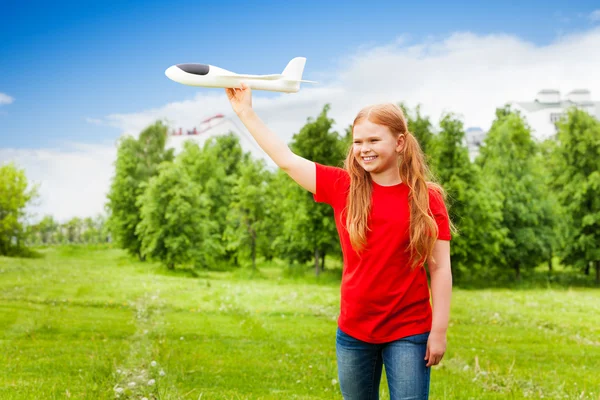 Small girl holds airplane toy — Stock Photo, Image