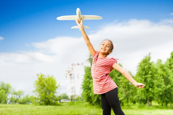 Small girl holds airplane toy — Stock Photo, Image
