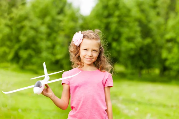 Piccola ragazza tiene giocattolo aeroplano — Foto Stock