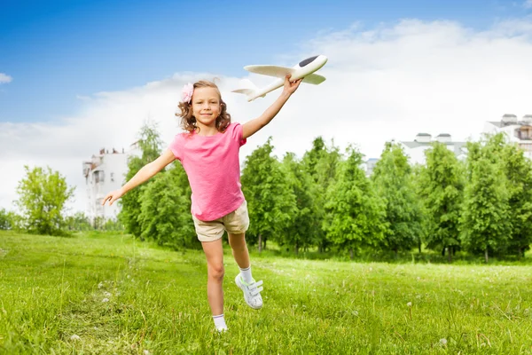 Small girl holds airplane toy — Stock Photo, Image