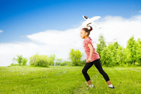 Small girl holds airplane toy — Stock Photo, Image