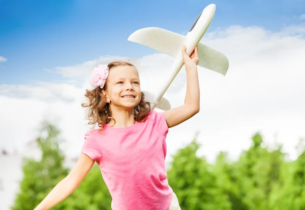 Menina pequena detém brinquedo avião — Fotografia de Stock