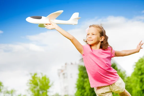 Klein meisje houdt vliegtuig speelgoed — Stockfoto
