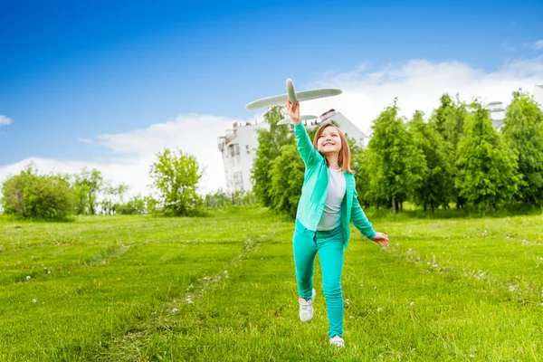 Девушка играет с игрушкой самолета — стоковое фото