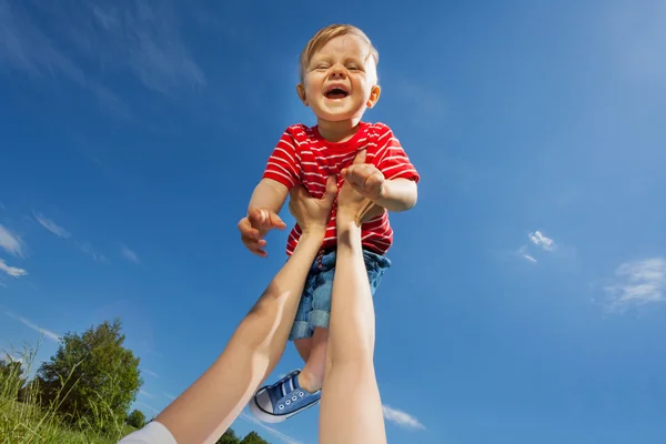 Mutter hebt lachenden Sohn in die Höhe — Stockfoto